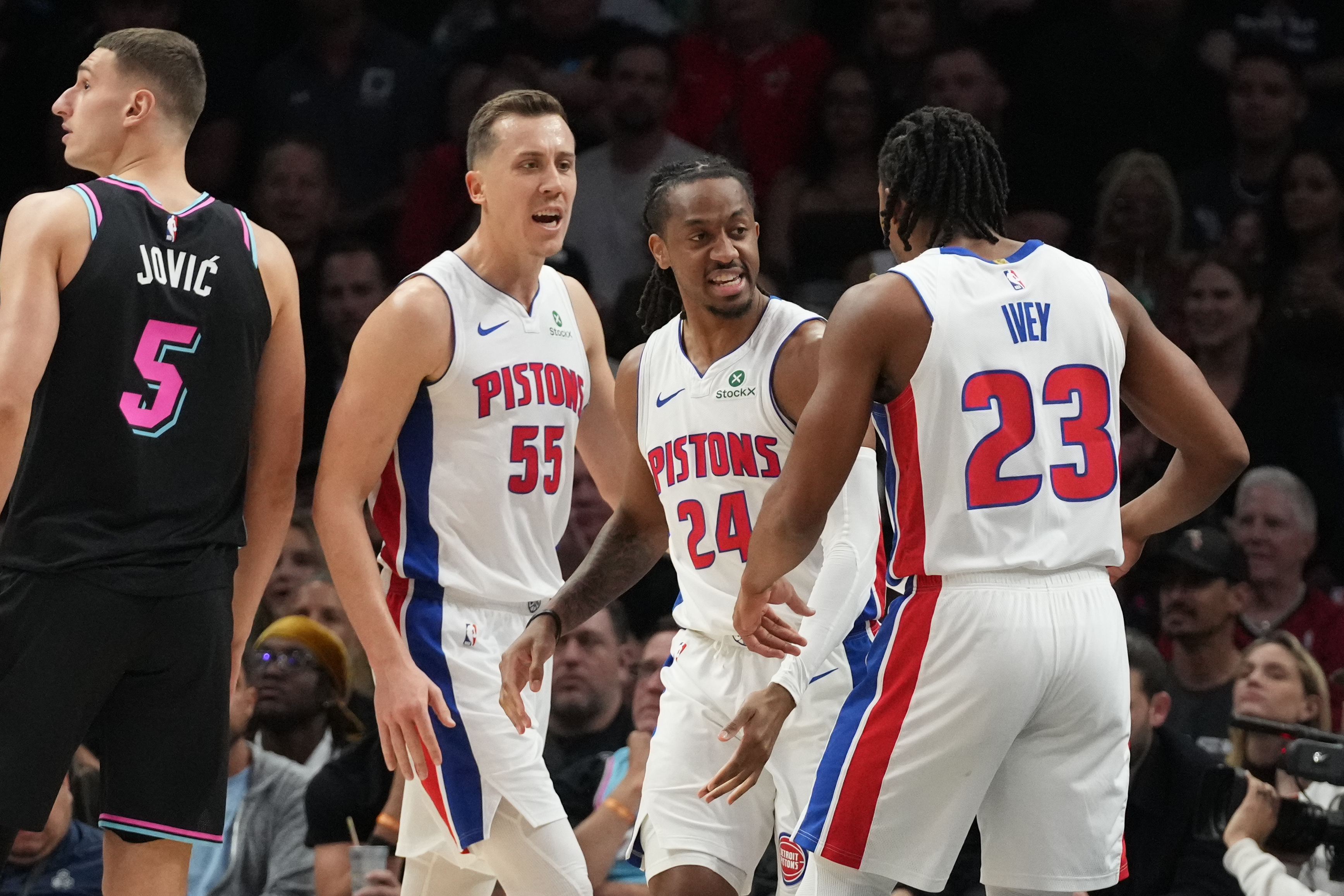 Detroit Pistons forward Duncan Robinson (55), guards Daniss Jenkins (24) and Jaden Ivey (23) reacts after Jenkins scored during the second half of an NBA basketball game against the Miami Heat Saturday, Nov. 29, 2025, in Miami. (AP Photo/Marta Lavandier)