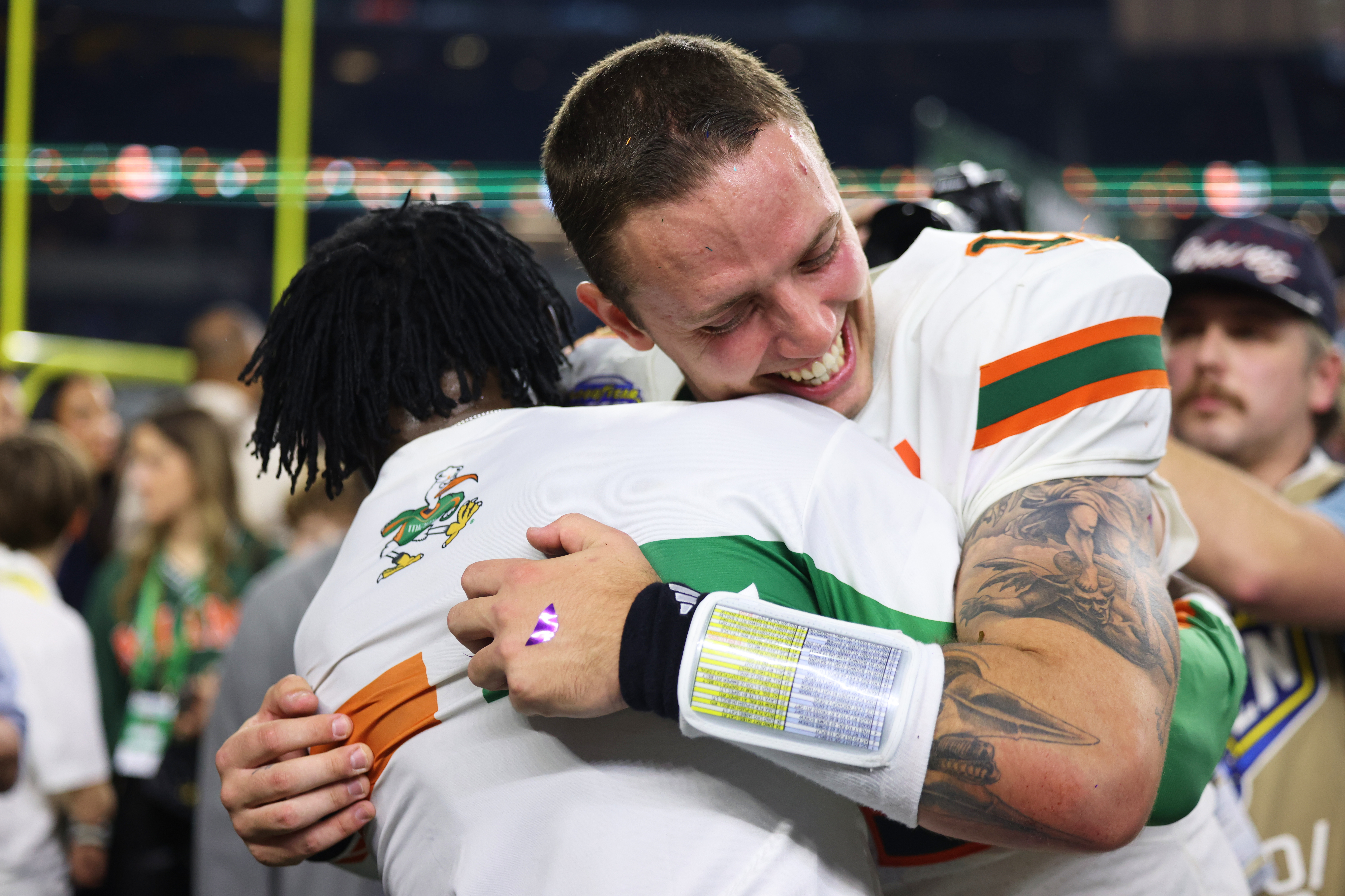 Miami quarterback Carson Beck, right, is hugged by former NFL player Michael Irvin following the Cotton Bowl College Football Playoff quarterfinal game against Ohio State Wednesday, Dec. 31, 2025, in Arlington, Texas. (AP Photo/Gareth Patterson)