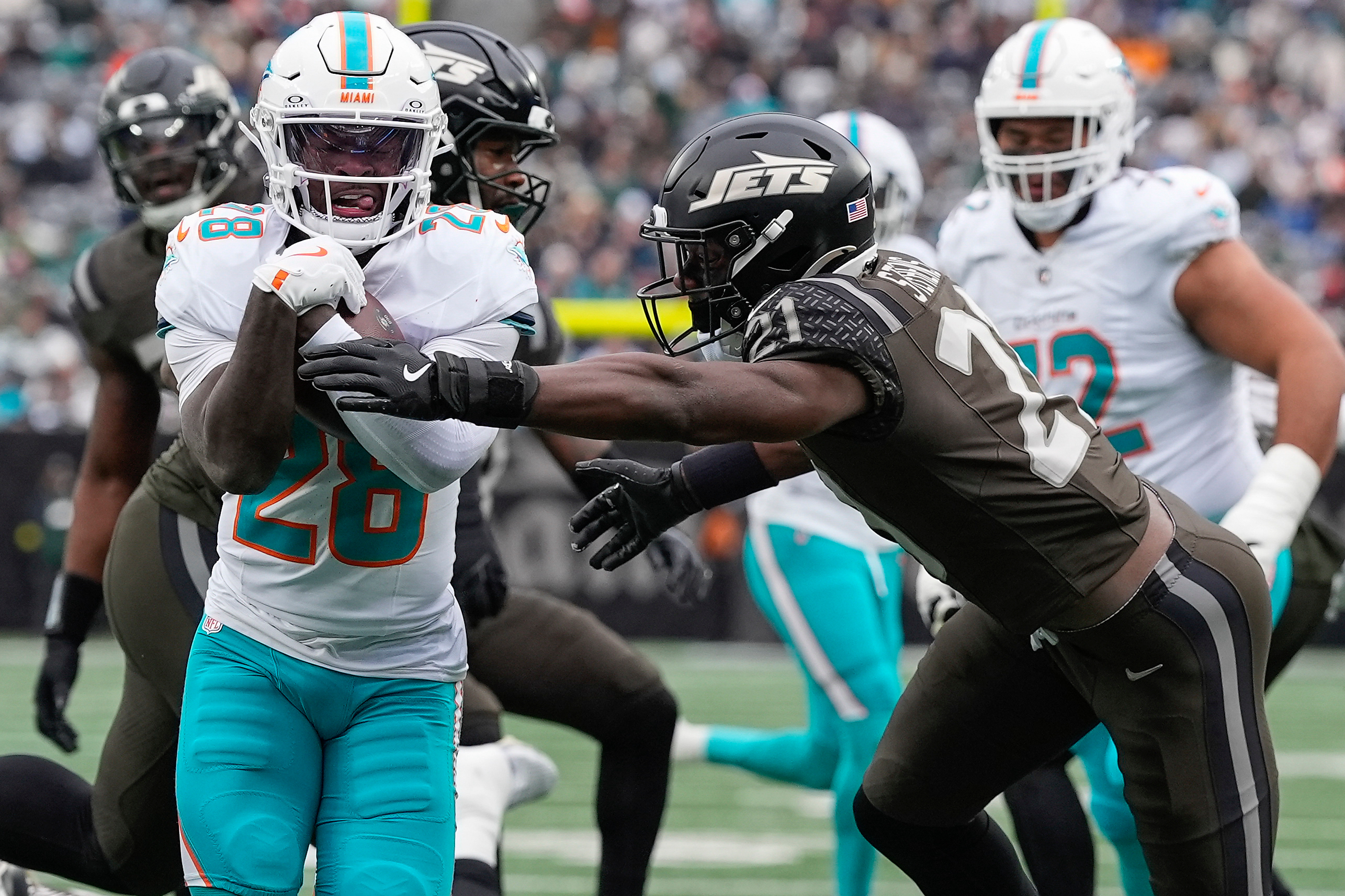 Miami Dolphins running back De'Von Achane (28) carries the ball for a touchdown against New York Jets cornerback Brandon Stephens (21) during the first quarter of an NFL football game, Sunday, Dec. 7, 2025, in East Rutherford, N.J. (AP Photo/Yuki Iwamura)